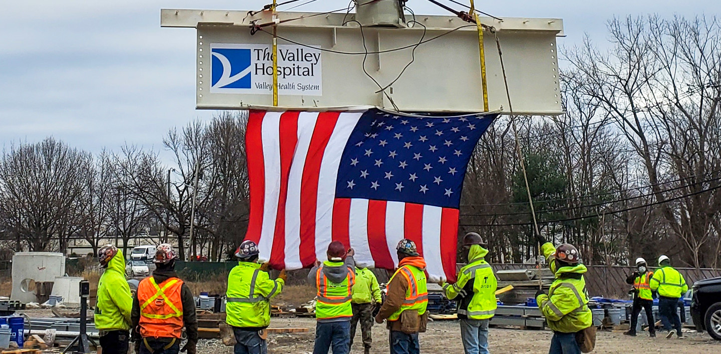 american flag hoisted at construction site