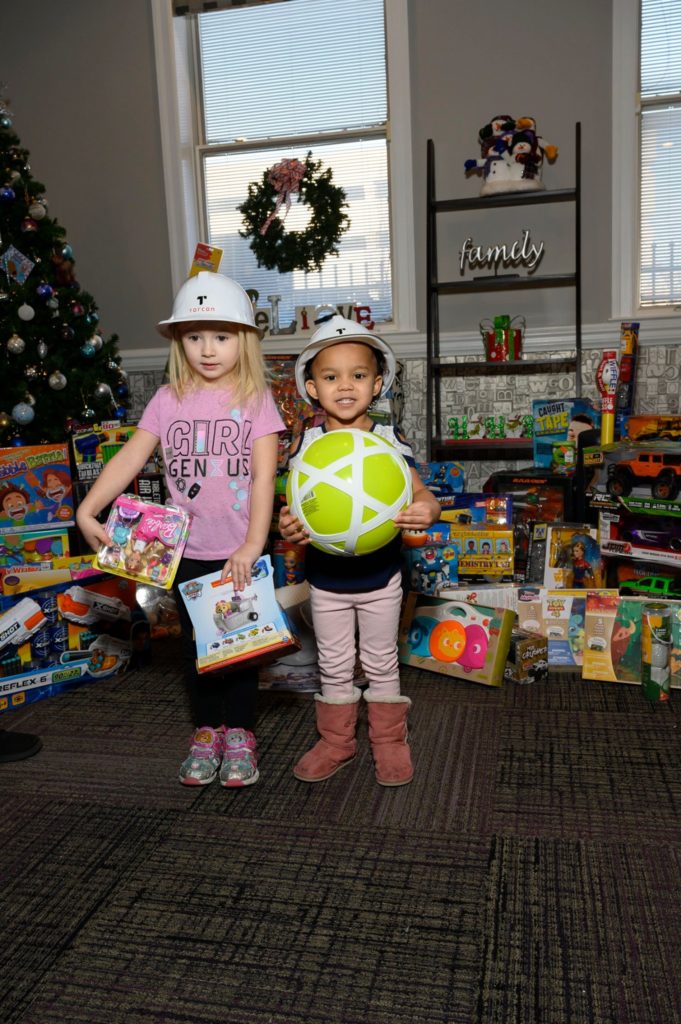 Litle kids at the Ronald McDonald House holding new christmas presents