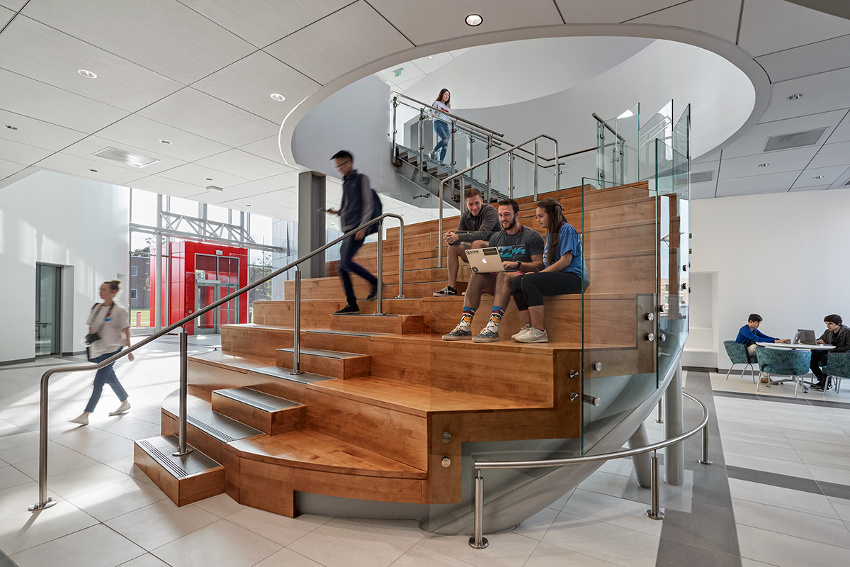 students sitting on central staircase within Richard Weeks Hall of Engineering